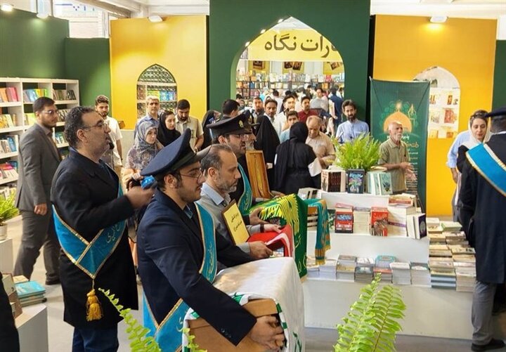 مردم از پرچم امام رضا (As) در نمایشگاه کتاب استقبال می کنند